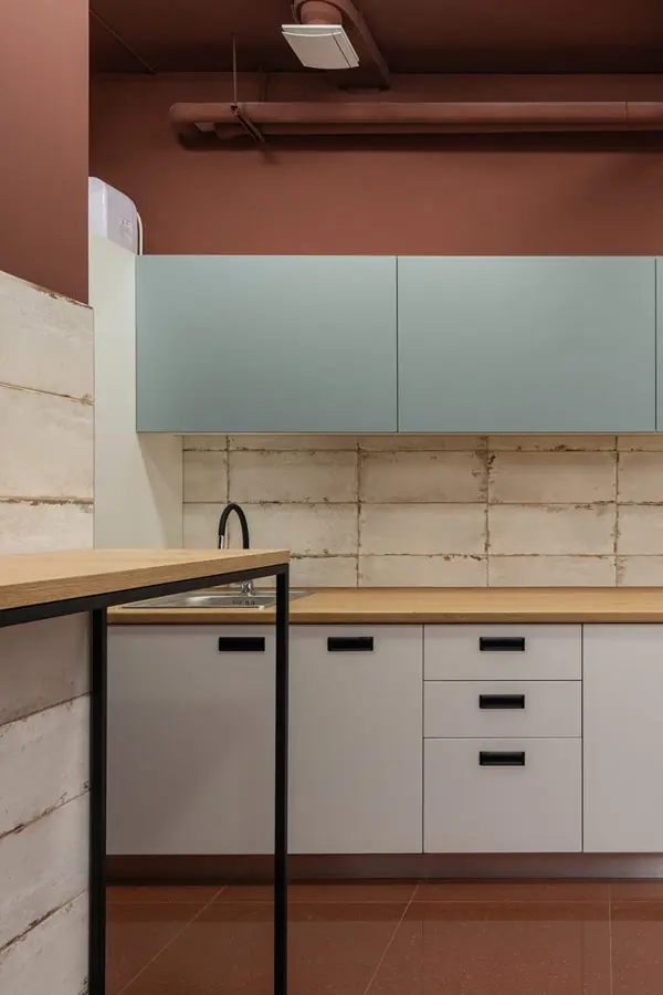 Colorida cocina con tono terrazo y contraste azulejos blanco roto.