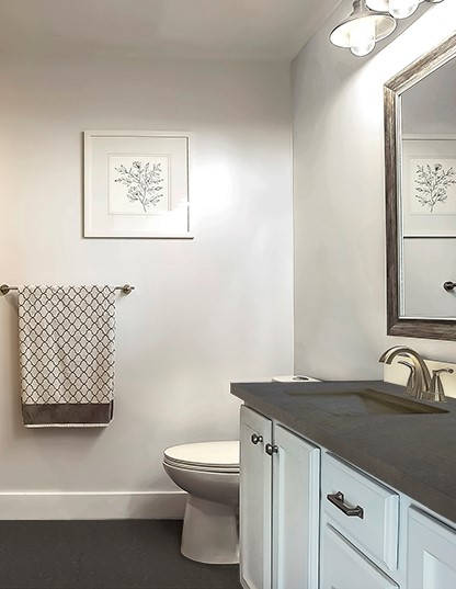 Baño con suelo de microcemento y encimera gris oscuro