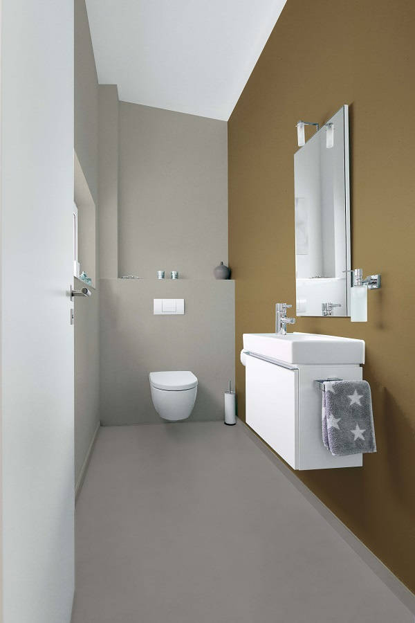 Baño de microcemento con pared acento de color marrón