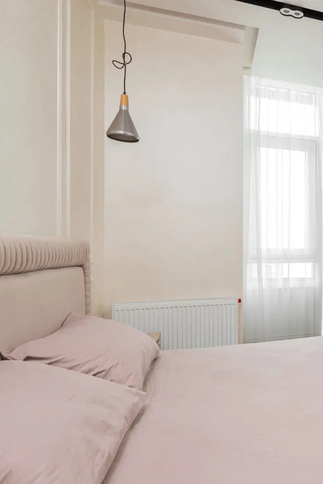 Acogedor dormitorio con cemento decorativo en la pared