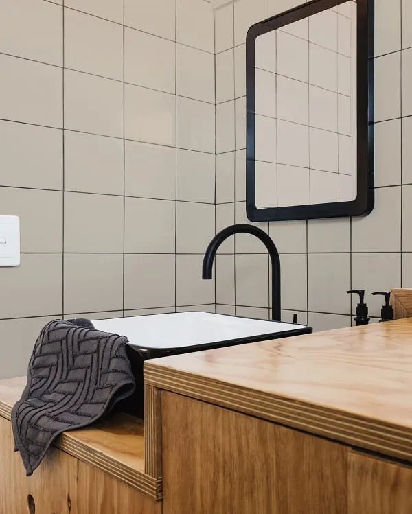 Baño con baldosas blancas y juntas negras