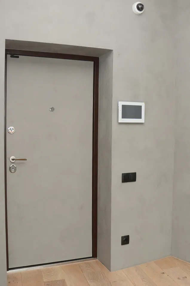 Entrada a apartamento con pared de estuco veneciano en tonalidad grisácea
