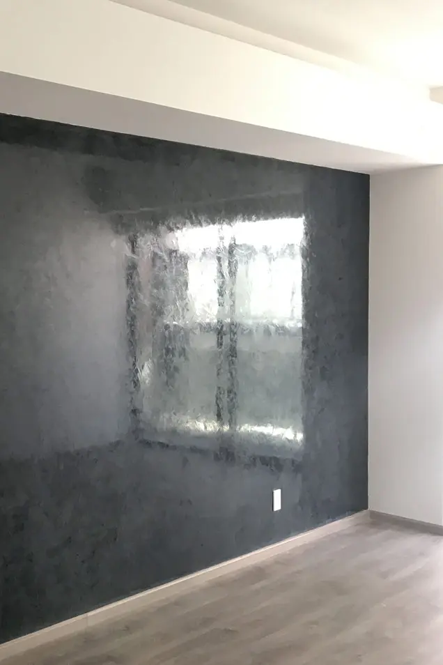 Dormitorio con pared decorada con estuco veneciano en tonos oscuros