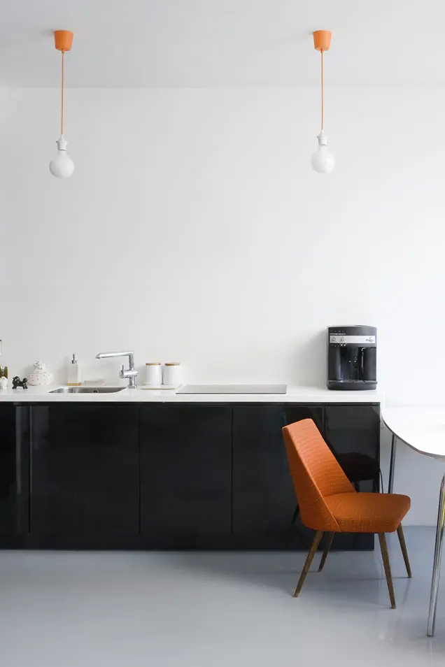Microcemento en suelo de cocina con muebles negros